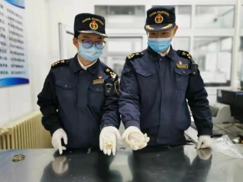 进境邮件藏象牙手镯、胸针 天津海关截获70克象牙制品-1.jpg